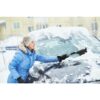 Woman cleaning car from snow